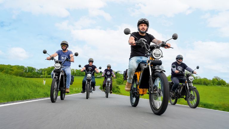 Mopedix Elektroroller fahren im Konvoi auf einer Landstrasse